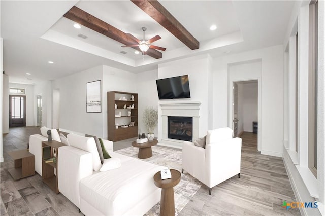 1386 Lyme Park, Bulverde, TX 78163 - living area featuring a glass covered fireplace, a tray ceiling, ceiling fan, recessed lighting, and light wood-style floors