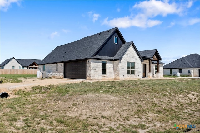 rear view of house with a garage and a yard