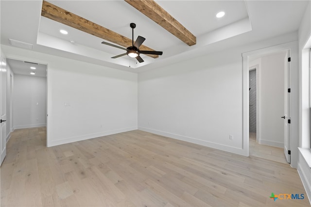 unfurnished room featuring light hardwood / wood-style flooring, ceiling fan, a raised ceiling, and beam ceiling