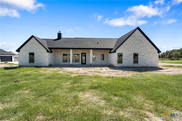 rear view of house with a patio area and a lawn