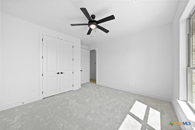 unfurnished bedroom featuring a closet, light carpet, and ceiling fan