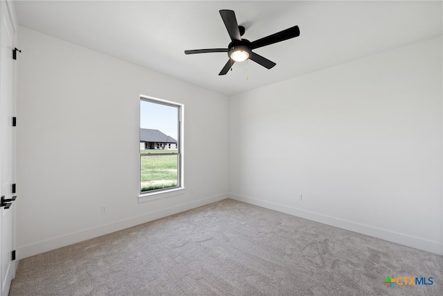 carpeted spare room with ceiling fan