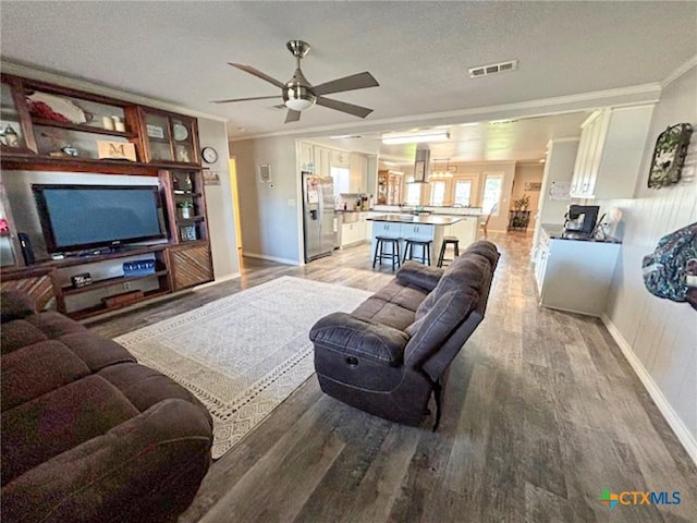 living room featuring crown molding, hardwood / wood-style floors, a textured ceiling, and ceiling fan