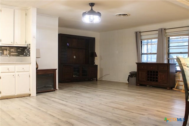 110 Crockett St, Port Lavaca, TX 77979 - kitchen featuring light wood-type flooring, white cabinets, tasteful backsplash, and light countertops