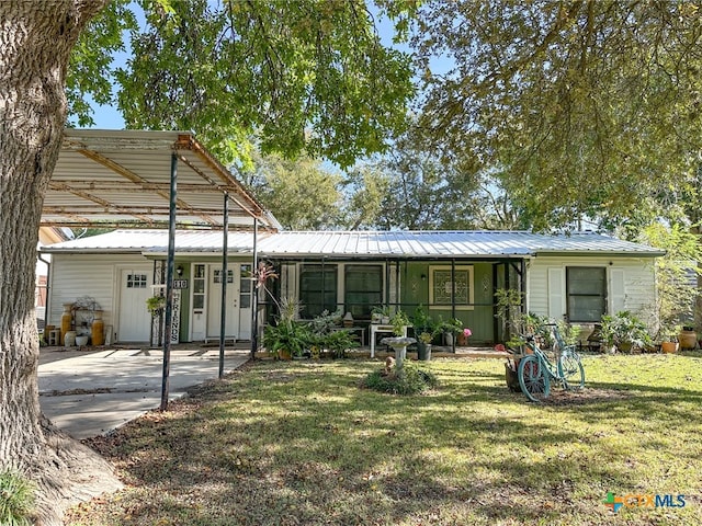 rear view of property featuring a lawn and a carport