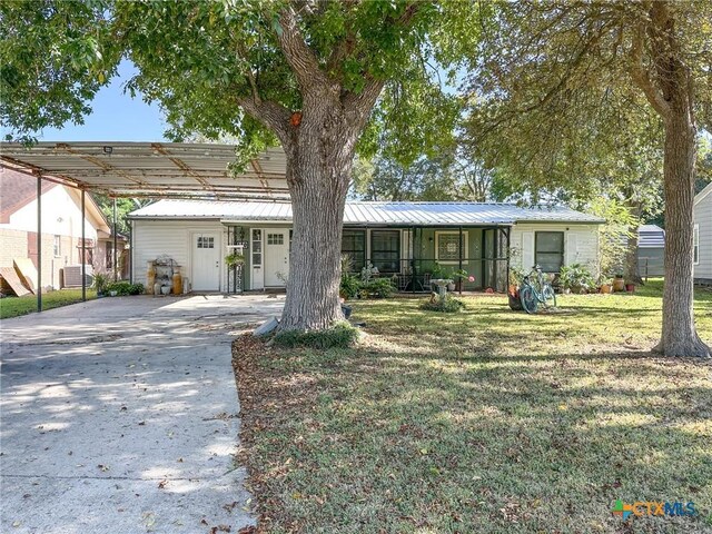 110 Crockett St, Port Lavaca, TX 77979 - view of front of home with driveway, a front yard, a metal roof, and a detached carport