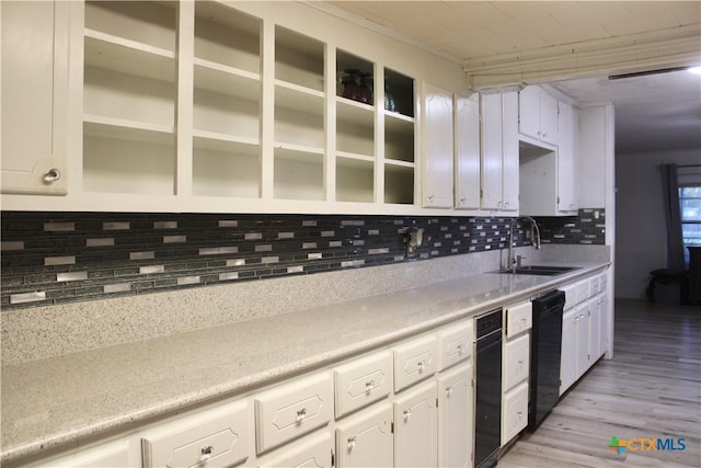 110 Crockett St, Port Lavaca, TX 77979 - kitchen with dishwasher, white cabinets, light wood-type flooring, decorative backsplash, and light countertops