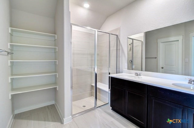 980 Gray Cloud Dr, New Braunfels, TX 78130 - bathroom featuring a shower stall, double vanity, lofted ceiling, and baseboards