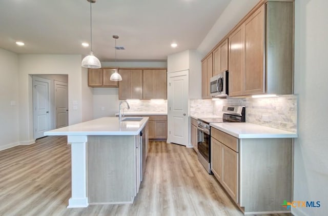 980 Gray Cloud Dr, New Braunfels, TX 78130 - kitchen with stainless steel appliances, a sink, light wood-type flooring, backsplash, and a kitchen island with sink