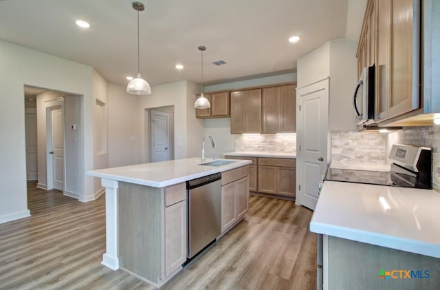 980 Gray Cloud Dr, New Braunfels, TX 78130 - kitchen featuring appliances with stainless steel finishes, a sink, light wood finished floors, a kitchen island with sink, and recessed lighting