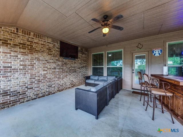 view of patio with ceiling fan, a bar, and an outdoor hangout area