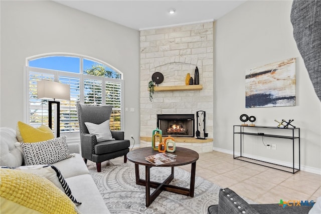 tiled living room featuring a stone fireplace