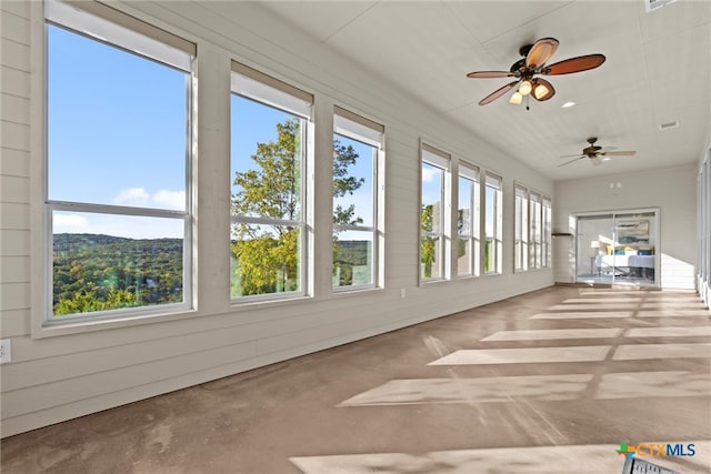 unfurnished sunroom with a wealth of natural light and ceiling fan