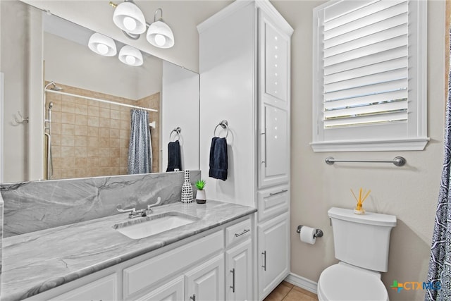 bathroom featuring tile patterned flooring, curtained shower, vanity, and toilet