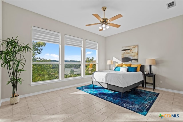 tiled bedroom with multiple windows and ceiling fan