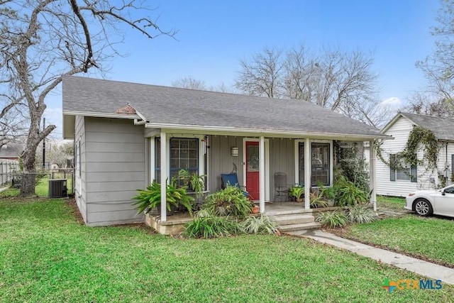 view of front facade featuring covered porch, central AC, and a front yard