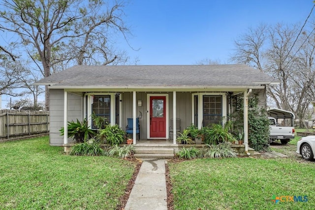 bungalow-style home with a front yard, a porch, and a carport