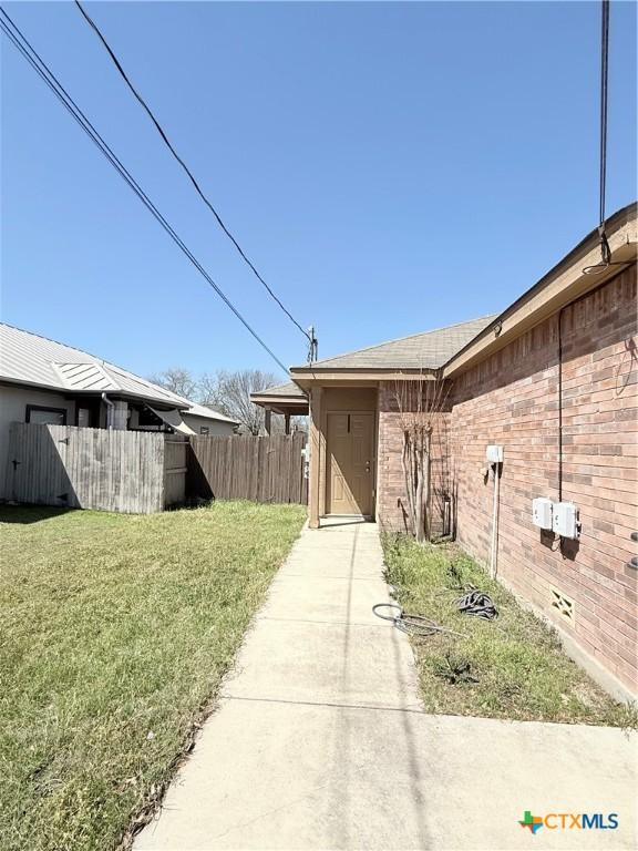 209 Anne Louise Dr, New Braunfels, TX 78130 - view of side of home featuring a yard, fence, and brick siding