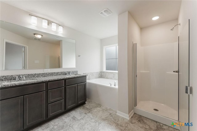 bathroom featuring vanity and independent shower and bath