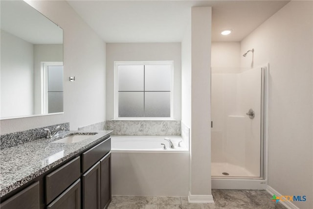 bathroom with vanity and independent shower and bath