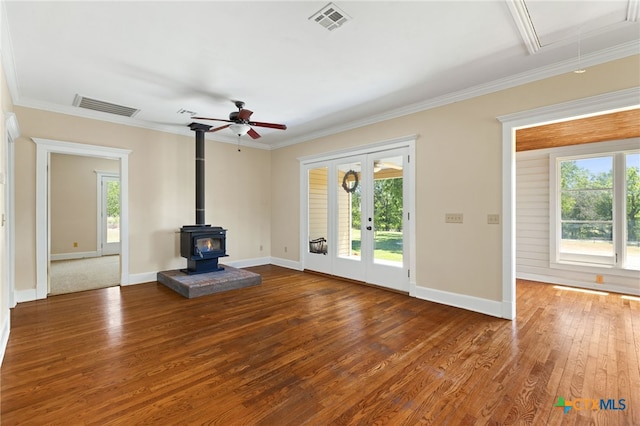 395 Dale Ln, Dale, TX 78616 - unfurnished living room with a wood stove, french doors, wood finished floors, a ceiling fan, and crown molding