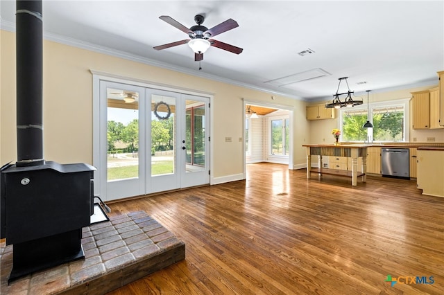 395 Dale Ln, Dale, TX 78616 - living area featuring a wood stove, crown molding, ceiling fan, attic access, and wood finished floors