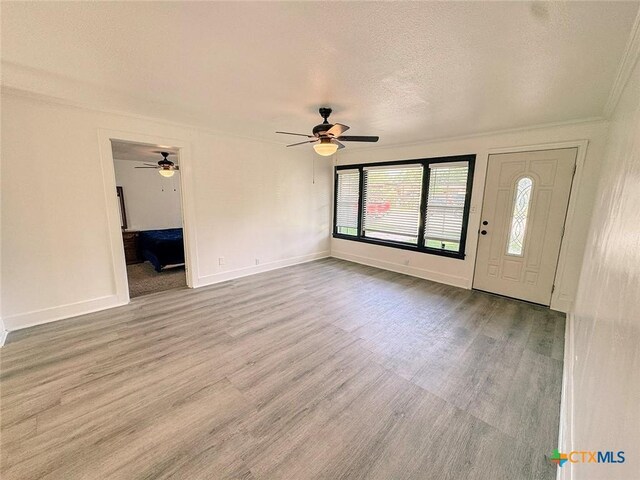 3007 Meadowlane St, Victoria, TX 77901 - foyer entrance featuring wood finished floors, crown molding, ceiling fan, baseboards, and a textured ceiling
