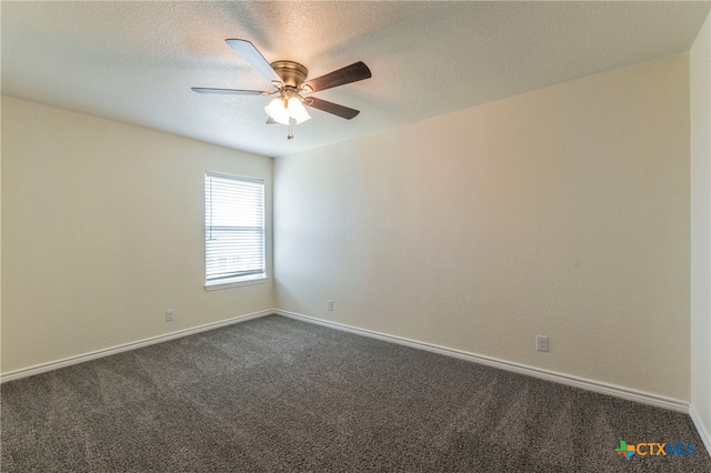 empty room with ceiling fan, a textured ceiling, and dark carpet