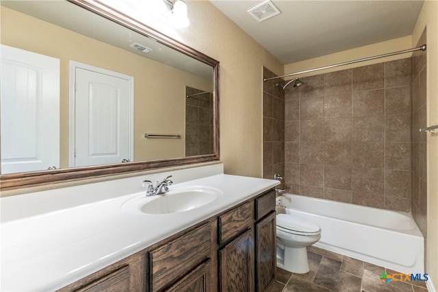 full bathroom with tiled shower / bath, a textured ceiling, toilet, and vanity