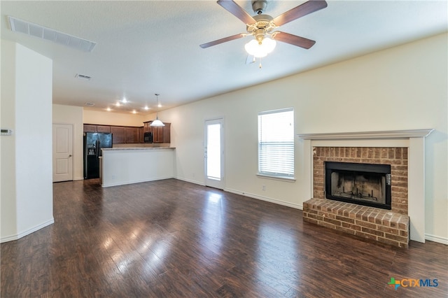 unfurnished living room featuring a fireplace, dark wood-type flooring, and ceiling fan