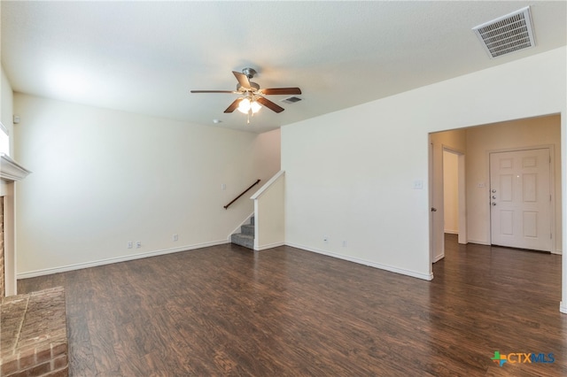 unfurnished living room featuring a fireplace, dark hardwood / wood-style flooring, and ceiling fan