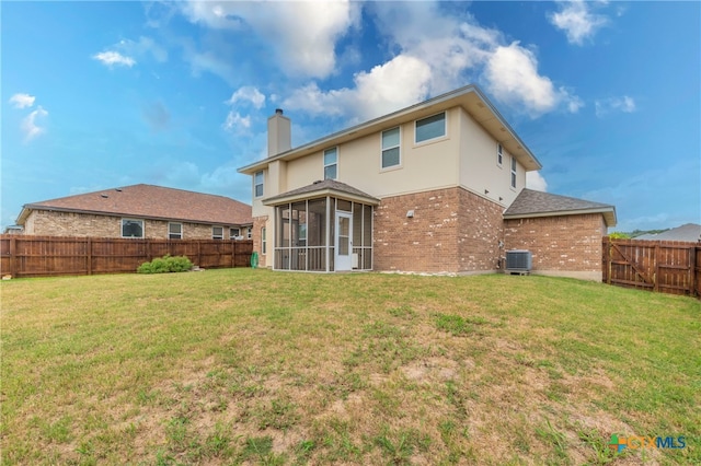 back of house with a yard, a sunroom, and central AC