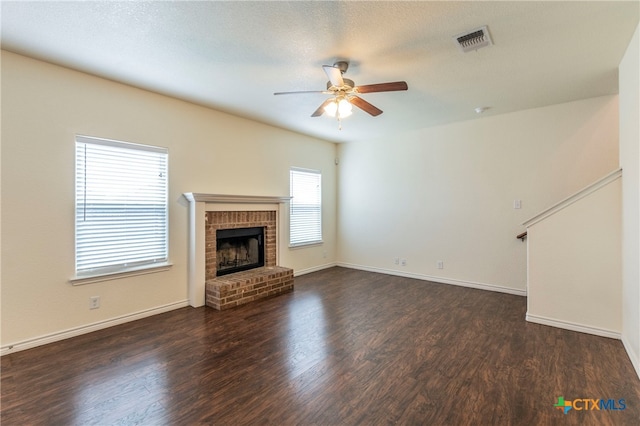 unfurnished living room featuring a fireplace, ceiling fan, a textured ceiling, and dark hardwood / wood-style flooring