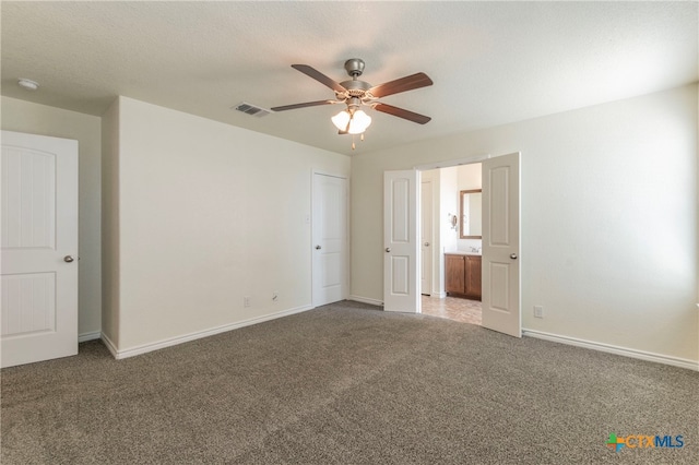 unfurnished bedroom with a textured ceiling, carpet, and ceiling fan