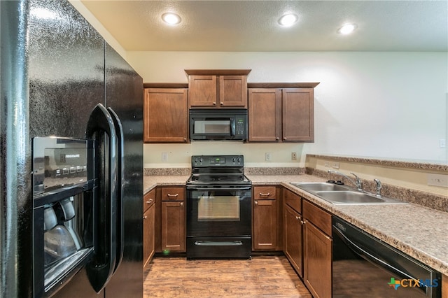 kitchen featuring light hardwood / wood-style floors, sink, and black appliances