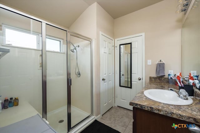 bathroom featuring tile patterned flooring, vanity, and walk in shower