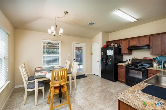 kitchen featuring lofted ceiling, black appliances, hanging light fixtures, a notable chandelier, and a healthy amount of sunlight