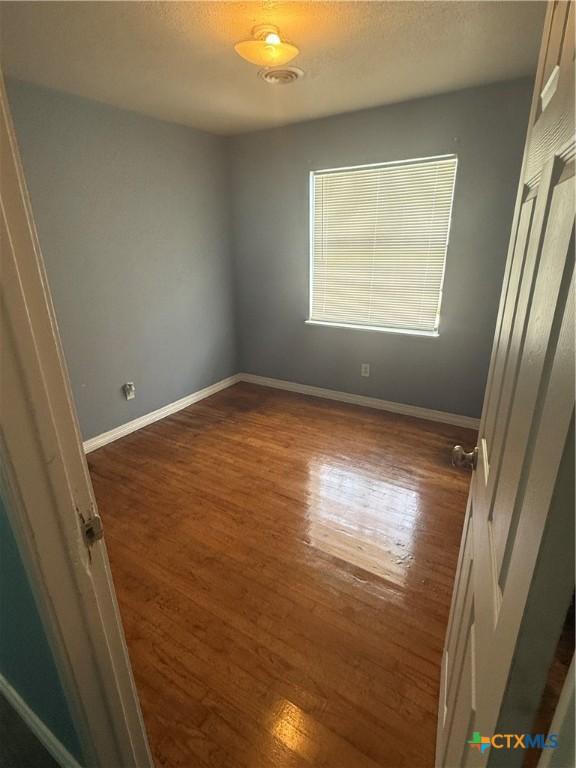 1309 W Ln, Killeen, TX 76549 - unfurnished bedroom with dark wood-style floors and baseboards