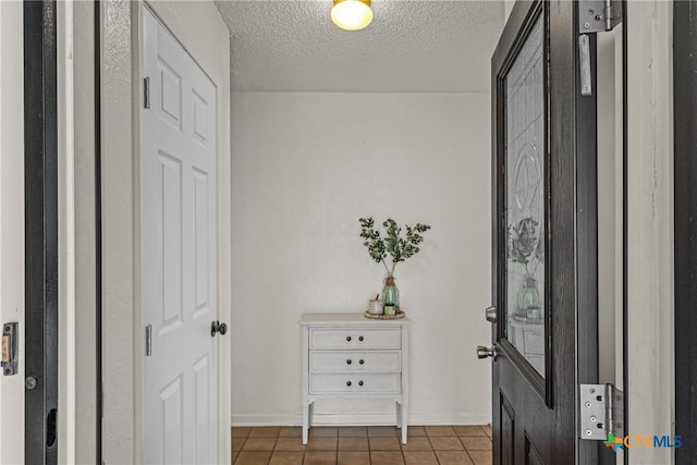 tiled entrance foyer featuring a textured ceiling