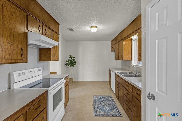 kitchen featuring a textured ceiling, white appliances, and sink