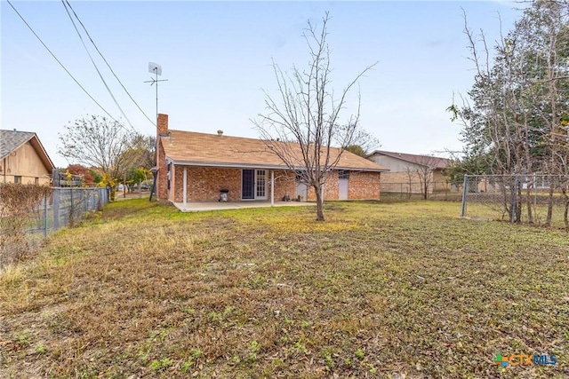 rear view of house with a yard and a patio