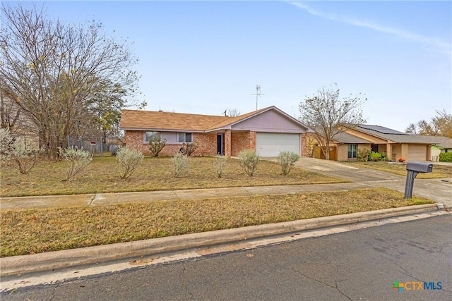 ranch-style home featuring a garage and a front lawn