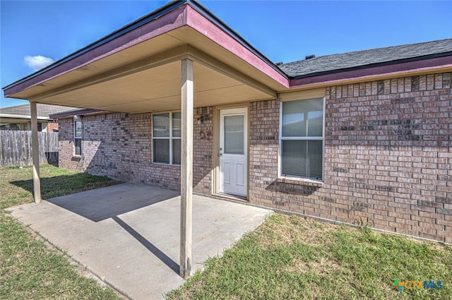 doorway to property featuring a patio and a yard