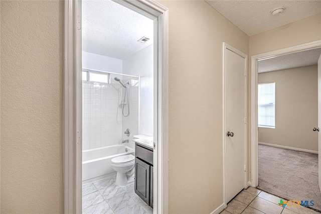 full bathroom featuring vanity, a textured ceiling, toilet, and tiled shower / bath