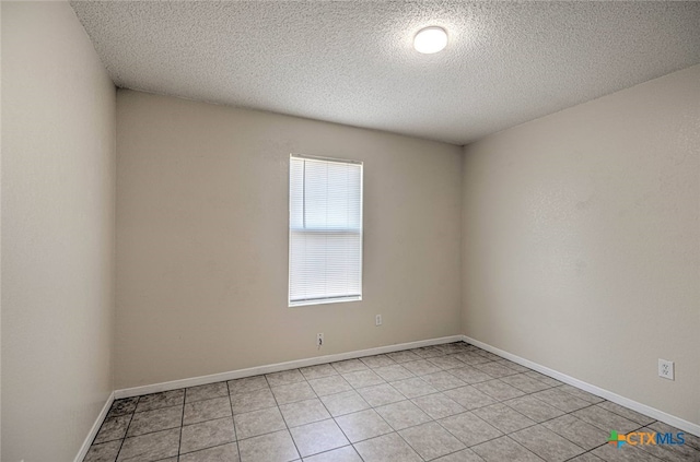 unfurnished room featuring a textured ceiling and light tile patterned floors