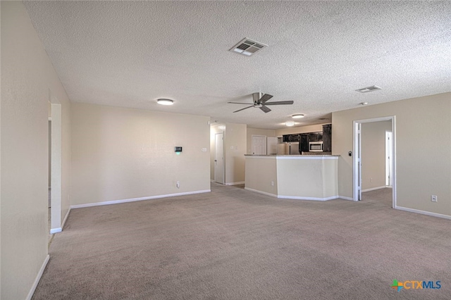 unfurnished living room with a textured ceiling, ceiling fan, and carpet floors