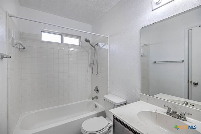 full bathroom with vanity, a textured ceiling, toilet, and tiled shower / bath