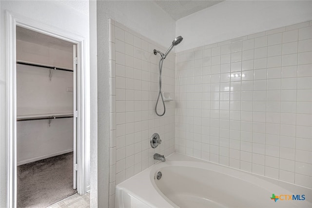 bathroom featuring tiled shower / bath and a textured ceiling