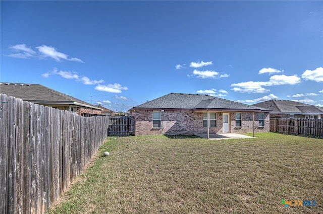 rear view of property featuring a patio and a yard