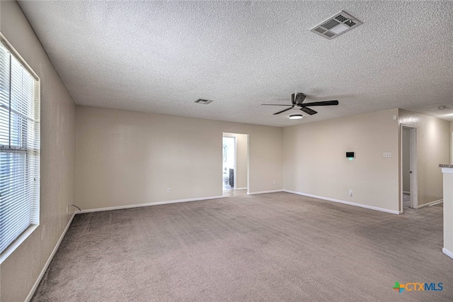 carpeted spare room featuring ceiling fan and a textured ceiling